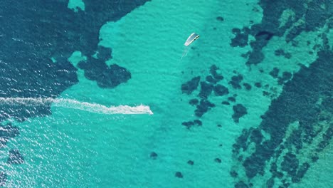 Kitesurfer-Cabalgando-Sobre-Un-Agua-Clara-Hasta-Llegar-A-La-Playa,-Arrecifes-Y-Diferentes-Patrones-Visibles-Bajo-El-Agua