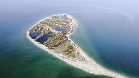 A-sand-island-with-pockets-of-water-on-it-in-the-middle-of-the-sea