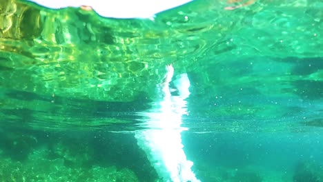 Junger-Taucher,-Der-Luftblasen-Auf-Smaragdgrünem,-Ruhigem-Meerwasser-In-Der-Nähe-Der-Küste-Im-Mittelmeer-Freisetzt