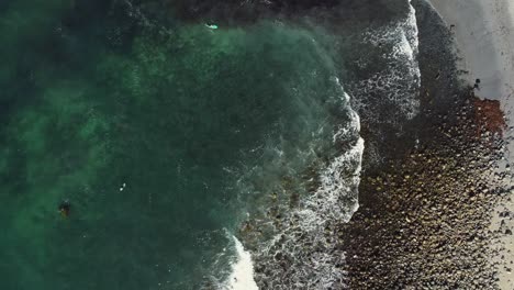 -Surfers-Group-enjoying-Turquoise-waves-during-summer-vacation,-Unstad-beach,-Lofoten,-birds-eye-view
