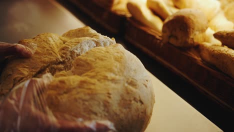 Slow-motion-tracking-shot-of-a-person-showing-a-cutted-big-bread