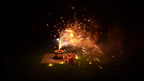 Fireworks-in-plant-pot-in-yard-smoke-with-bright-clors-and-cracking-sparks