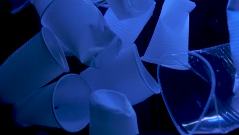 Plastikbecher,-Die-Im-Wasser-Schwimmen,-Blaues-Licht