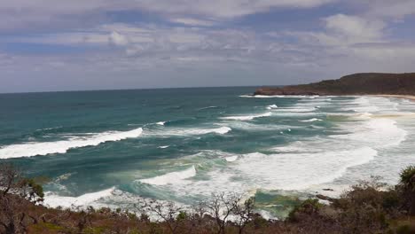 High-viewpoint-of-breathtaking-ocean-waves-coming-onto-the-beach-on-the-Noosa-National-park-hike-in-Noosa-Heads,-Australia