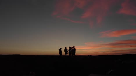Aerial-flight-by-group-of-friends-as-silhouette-against-desert-sunset