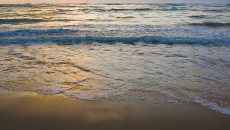 A-golden-reflection-visible-on-sand-wet-from-waves-on-Oahu-Hawaii