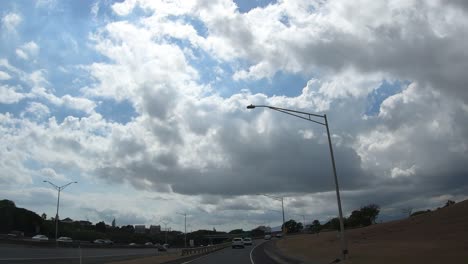 Driving-on-the-freeway-towards-Honolulu-on-Oahu-Hawaii-with-bright-skies-and-clouds-and-other-cars-and-trucks-around