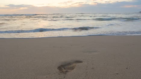 Ein-Einzelner-Fußabdruck-Ist-Im-Sand-Sichtbar,-Wo-Die-Wellen-Während-Eines-Hawaiianischen-Sonnenuntergangs-An-Der-Nordküste-Von-Oahu-Hereinspülen
