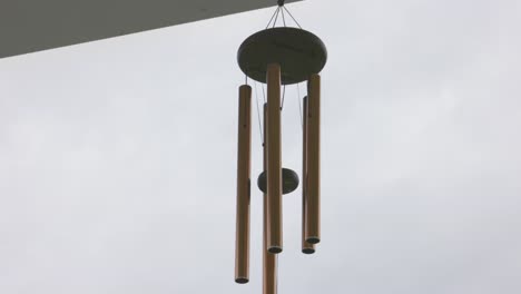 Tilt-up-close-up-of-wind-chimes-on-a-cloudy-day