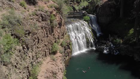 Proximity-drone-aerial-reveals-cliff-jumper-at-beautiful-McCloud-Falls