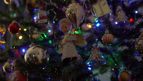 Angel-with-dirty-face-Christmas-decoration-hanging-on-tree-with-lights