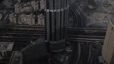 A-busy-highway-with-man-y-cars-driving-in-slow-motion,-surrounded-by-tall-buildings-and-skyscrapers-in-Dubai
