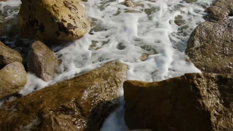 Close-shot-of-waves-through-the-rocks-in-slow-motion