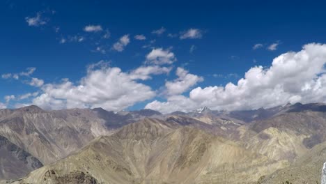 Beautiful-blue-skies-and-fast-moving-fluffy-white-clouds-over-the-dry-arid-himalaya-mountains