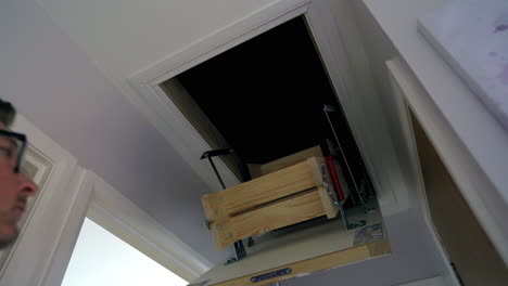 Dachbodenleiter-Männlich,-Der-Die-Leiter-Herunterzieht,-Um-Auf-Den-Dachboden-Oder-Dachboden-Im-Haus-Zuzugreifen