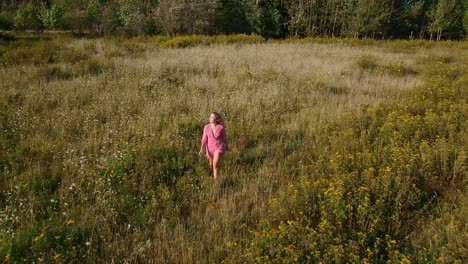 Beautiful-young-girl-walking-in-a-flower-field-during-the-spring-bloom-in-the-rural-countryside-of-Canada