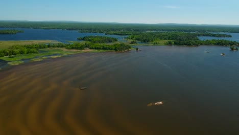Downward-panning-drone-shot-of-a-shallow-lake-with-sand-ripples-showing-on-a-beautiful-bright-spring-day-in-North-Bay,-Canada