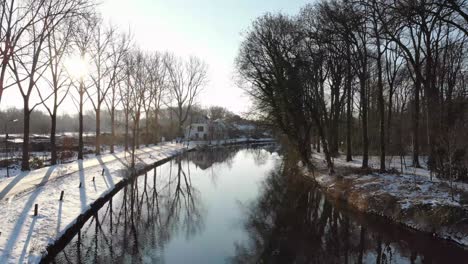 Drohnenaufnahme-Des-Flusses-Vecht-In-Utrecht-Bei-Sonnenaufgang-Im-Winter-Mit-Schnee