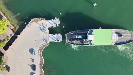 Top-down-aerial-drone-shot-of-car-ferry-arriving-at-Meilen-on-Lake-Zürich-in-Switzerland