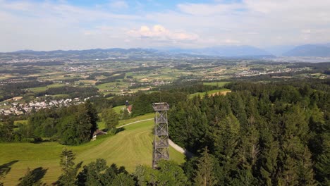 Toma-Aérea-De-Drones-Volando-Alrededor-De-La-Torre-De-Observación-Pfannenstiel-En-El-Cantón-De-Zúrich,-Suiza-Con-El-Condado-En-El-Fondo