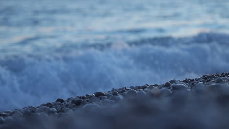Sea-waves-splashing-and-foaming-on-pebbles-beach,-closeup-water-shapes-in-slow-motion