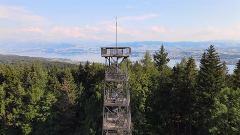 Aerial-drone-shot-flying-up-and-over-Pfannenstiel-observation-tower-and-revealing-lake-Zürich-in-the-background