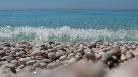 Emerald-sea-water-splashing-on-pebbles-beach-on-a-vacation-day-in-Mediterranean