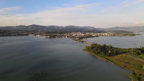 Cinematic-aerial-drone-shot-flying-over-lake-Zurich-towards-Rapperswil-at-sunset-in-summer