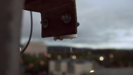 Close-Up-Of-Rain-Water-Dripping-From-Metal-Pipe-On-A-Rainy-Sunset