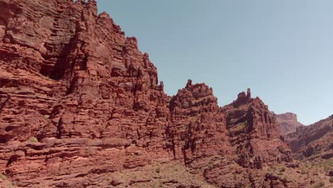 Rotating-aerial-of-deeply-eroded-red-sandstone-canyon-cliffs-in-Utah