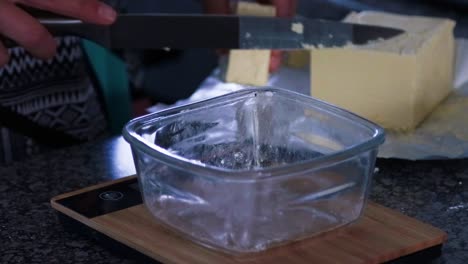 Weighing-butter-for-brownies-in-a-glass-bowl-on-a-bamboo-scale