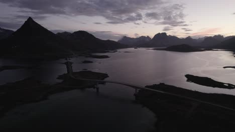 Aerial-view-approaching-Fredvang-bridges,-dawn-in-Lofoten,-Norway---pan,-drone-shot