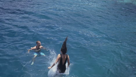 Woman-jumps-into-emerald-blue-water-on-Greek-island-of-Zakynthos,-slow-motion