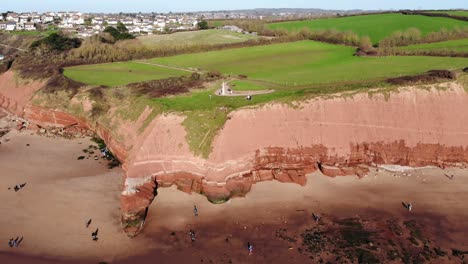 Aerial-Of-Orcombe-Cliffs-In-Exmouth-With-Visitors-On-Beach-On-Sunny-Day