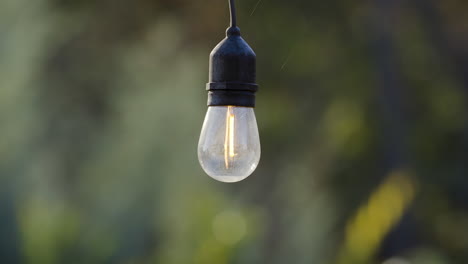 A-single-hanging-bulb-of-outdoor-decorative-string-lights,-is-on