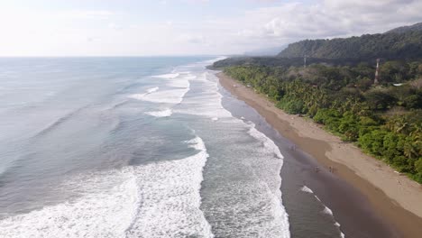 Aerial-view-of-ocean-waves-hitting-shore-in-Dominical-Beach-in-Costa-Rica,-Tracking-Shot