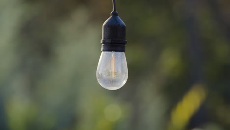 A-single-hanging-bulb-of-outdoor-decorative-string-lights,-is-off