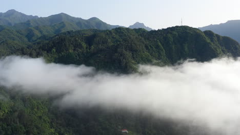 Vista-Aérea,-Interior-De-La-Isla-De-Madeira,-Portugal,-Colinas-Montañosas-Con-Selva-Tropical-Y-Picos-Sobre-Las-Nubes,-Disparo-De-Drones