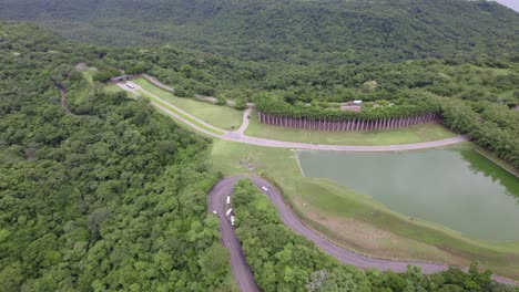 Aerial-dolly-in-of-road-and-pond-surrounded-by-woods-in-club-resort-near-Nacascolo-beach-in-Papagayo-Peninsula,-Costa-Rica