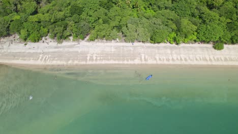 Aerial-truck-right-of-turquoise-sea-near-sand-shore-and-dense-green-woods-in-Nacascolo-beach,-Papagayo-Peninsula,-Costa-Rica