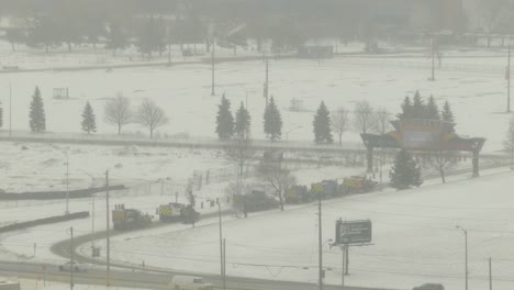 snow-plow-trucks-driving-along-highway-in-Canada-after-a-storm-during-cold-winter-season,-action-team-ready-to-removing-snow-and-ice-from-outdoor-road-restoring-normal-traffic-circulation