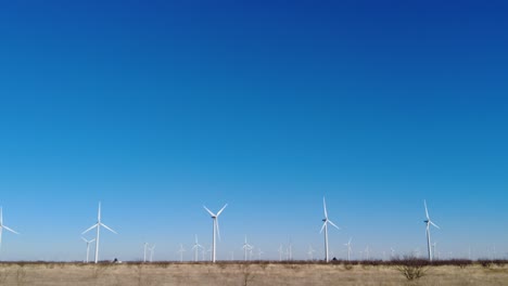 Panorámica-Lentamente-A-Través-De-Una-Fila-De-Turbinas-Eólicas-En-Las-Zonas-Rurales-Del-Oeste-De-Texas