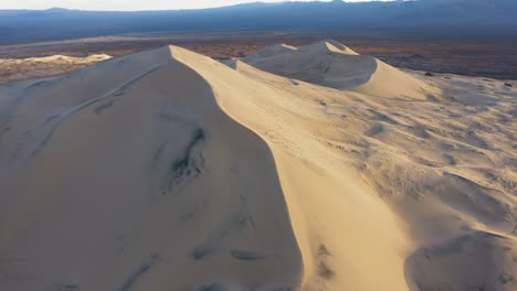 Orbital-shot-of-singing-Kelso-dunes-in-California-Mojave-desert,-panoramic-drone-view