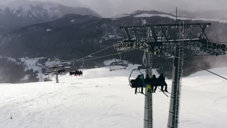 AERIAL---Ski-lift-in-mountains-on-a-sunny-day-at-Kolasin-ski-resort,-Montenegro