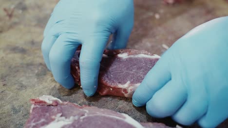 Close-up-of-a-butcher-placing-down-a-prime-cut-of-rib-steak
