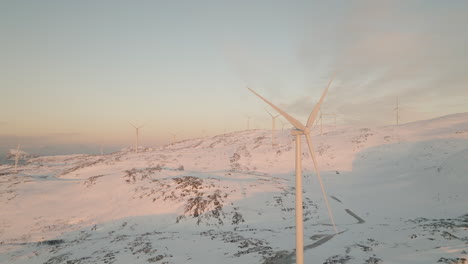 Zeitlupe-Von-Windkraftanlagen,-Die-Alternative-Energie-Auf-Einem-Schneebedeckten-Berg-In-Kvaloya,-Norwegen,-Bei-Einem-Wintersonnenaufgang-Erzeugen