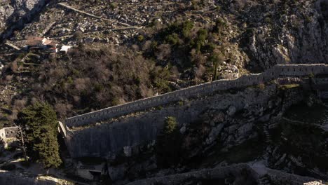 AERIAL---Ancient-city-walls,-Kotor,-Montenegro,-truck-right