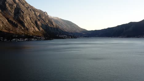 AERIAL---Bay-of-Kotor-under-a-clear,-blue-sky,-Kotor,-Montenegro,-rising-shot