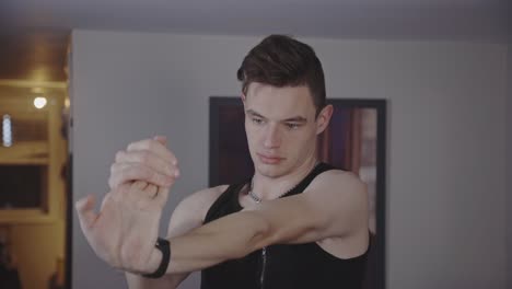 Athletic-Guy-Doing-Wrist-Extension-Stretch-Fingers-Up-Exercise-At-Home