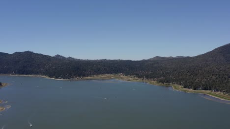 A-beautiful-drone-shot-descending-towards-the-water-in-Big-Bear-Lake-in-San-Bernardino-County,-California